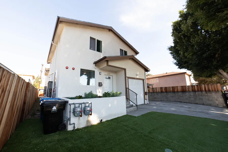 Side view of the two storey East 54th Street house in Los Angeles showing the upper unit and the side yard