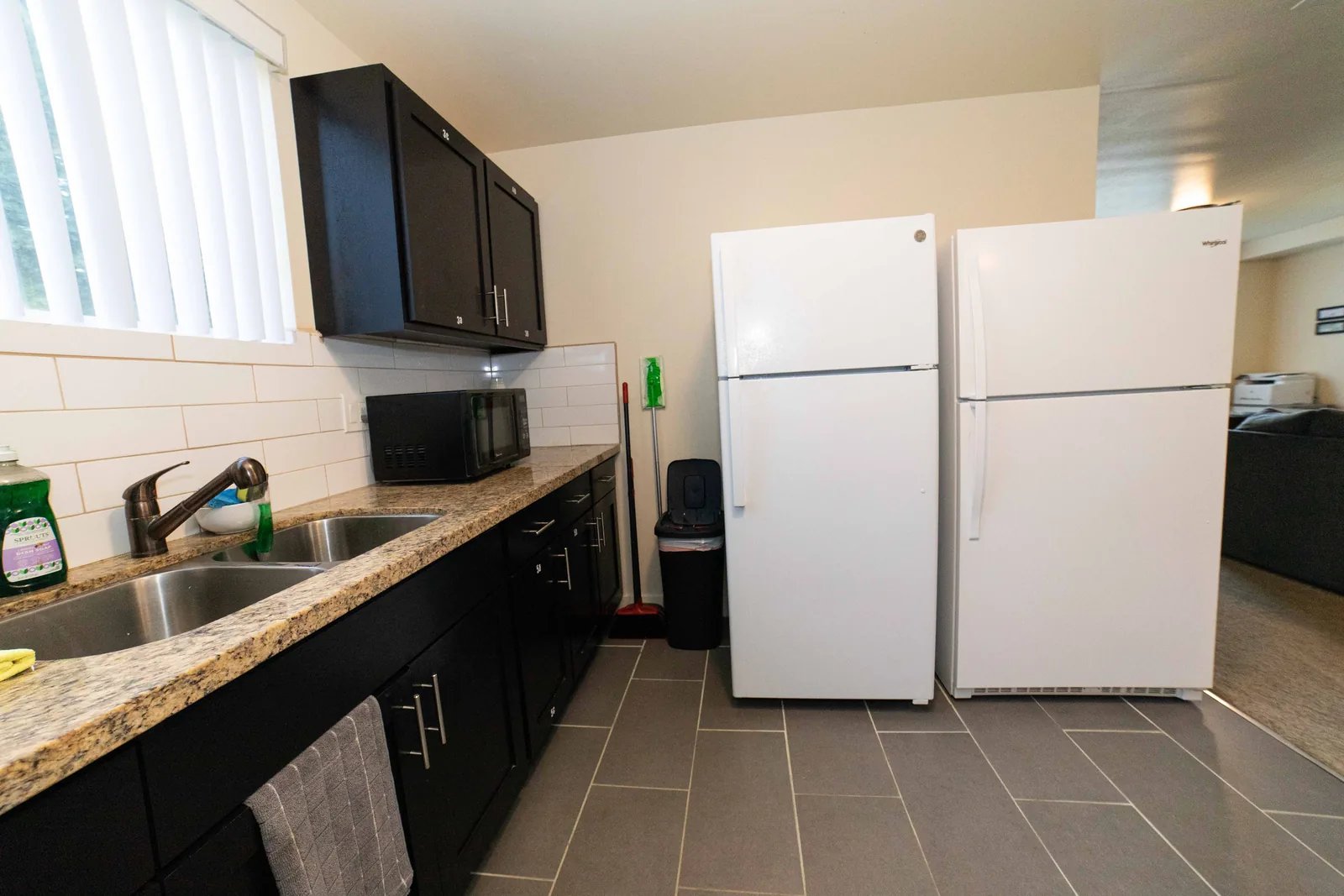 Kitchen sink counter and two shared refrigerators in the East 54th Street house in Los Angeles
