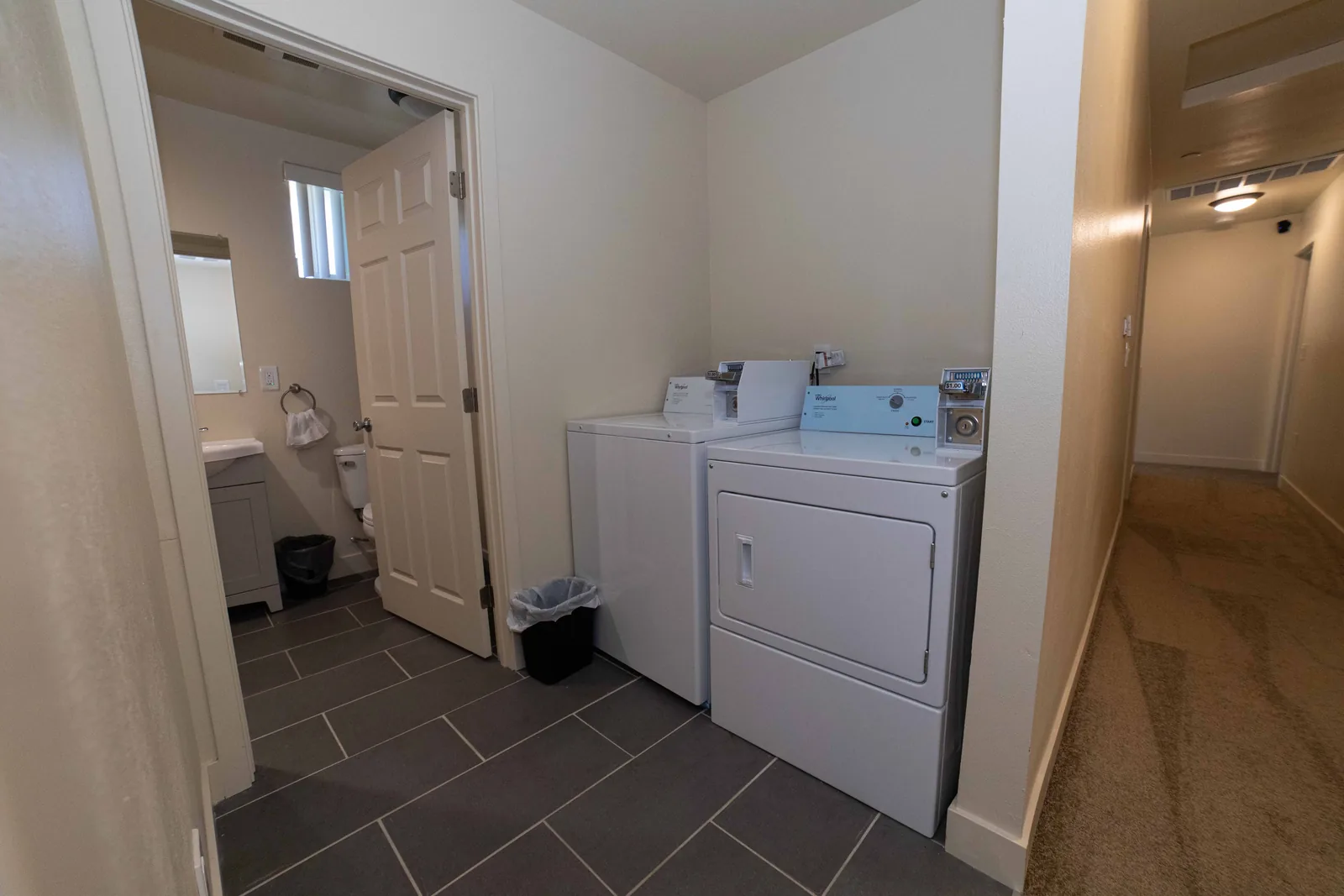 Laundry area with a washer and dryer beside the bathroom at the East 54th Street house