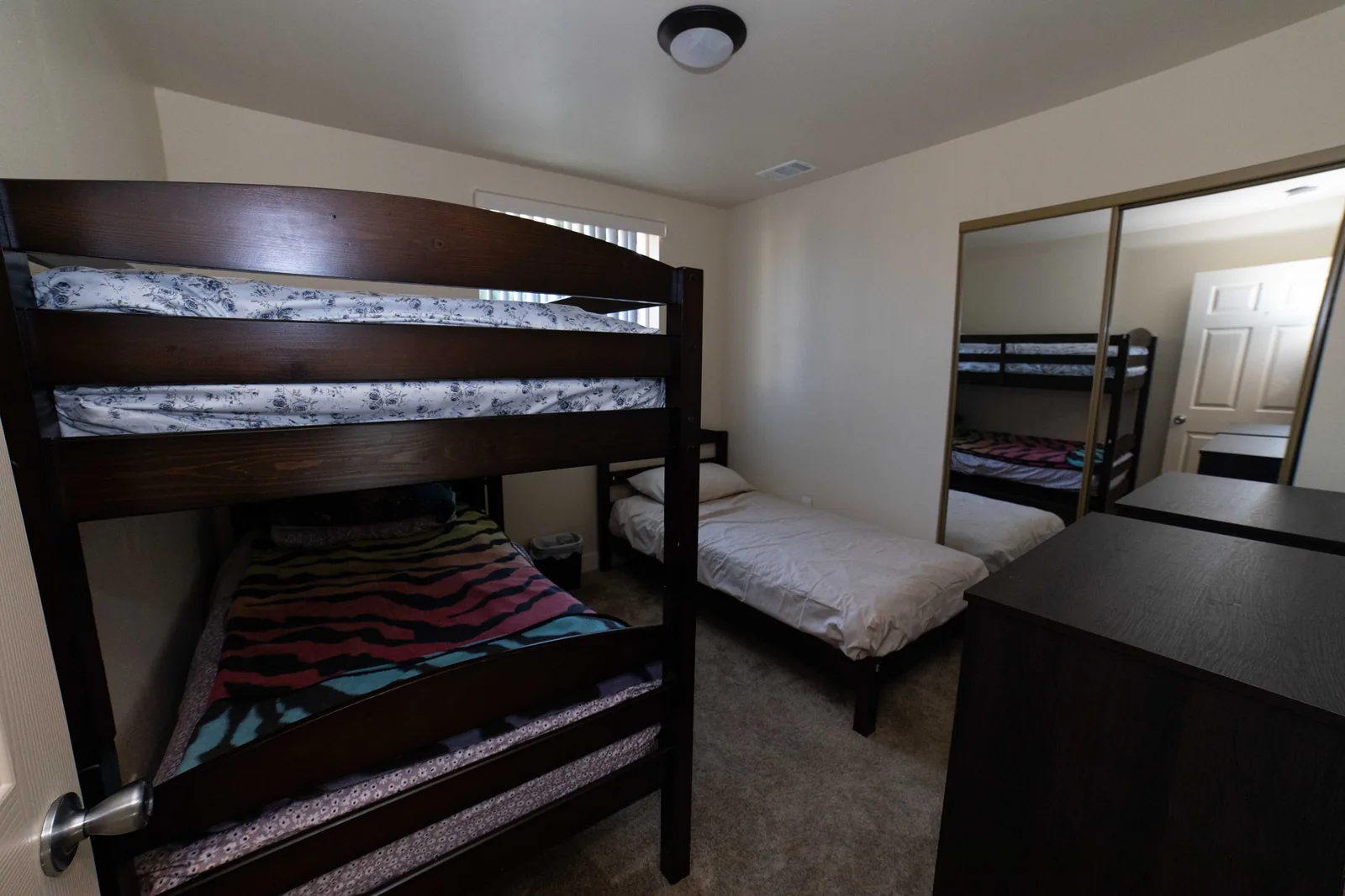 Shared bedroom at the East 54th Street house with a wooden bunk bed and a single bed