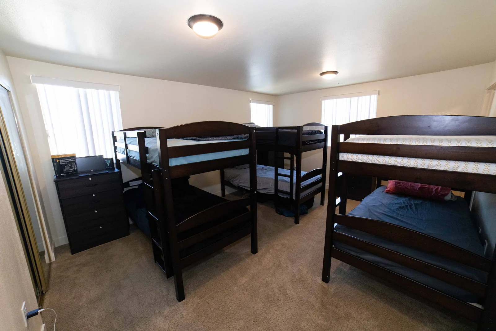 Shared bedroom at the East 54th Street house with bunk beds a mirrored closet and a chest of drawers
