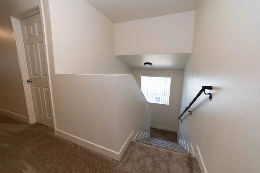 Carpeted staircase and landing inside the East 54th Street shared housing home