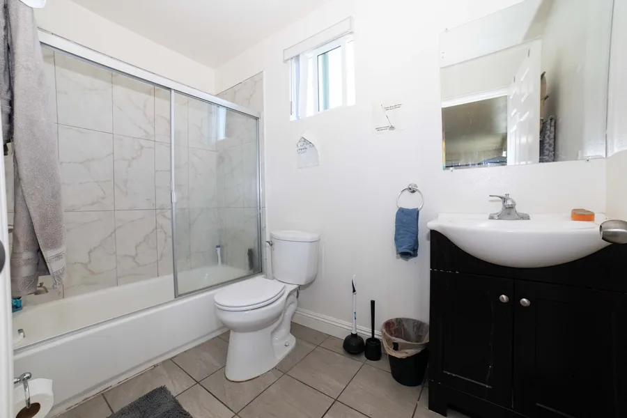 Bathroom at the West 42nd Street house with a glass door shower a vanity and a tiled floor