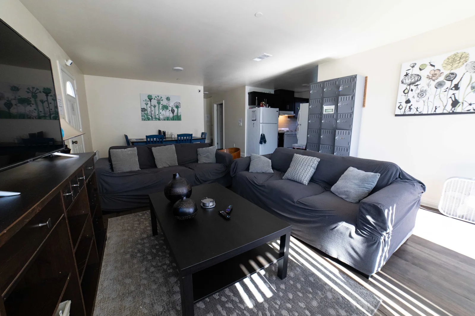 Common room at the West 42nd Street house with sofas a low table and a wall of lockable mail boxes