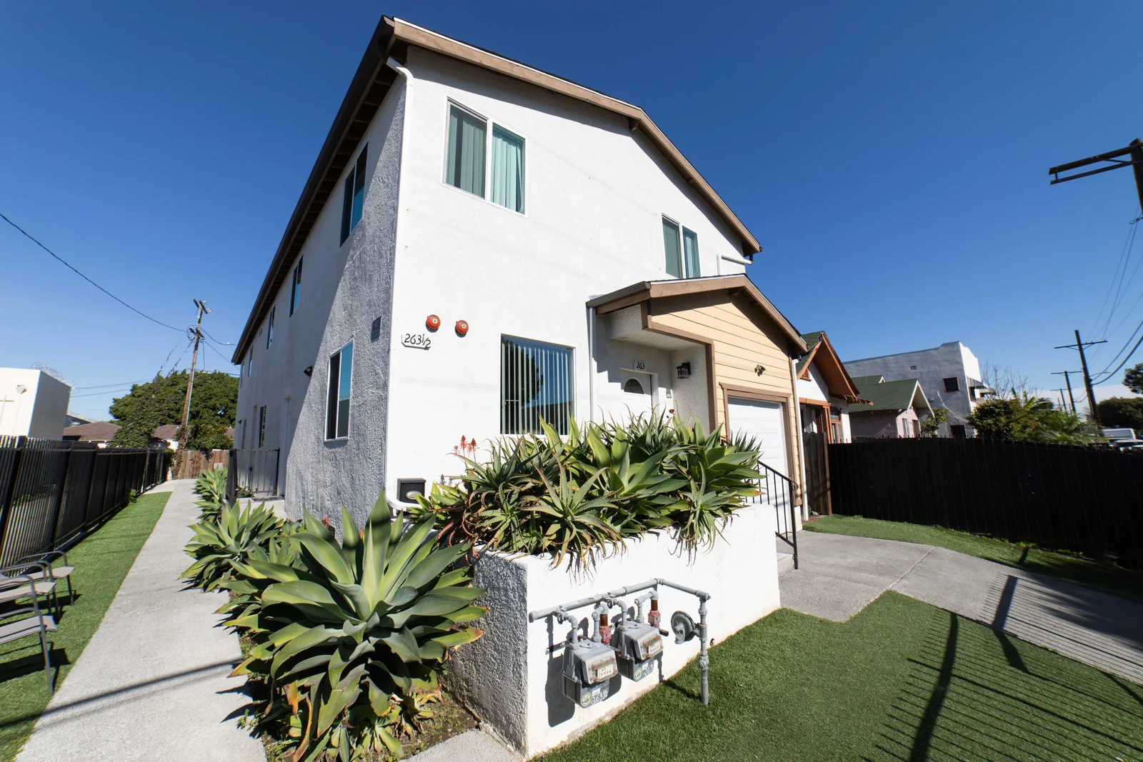Walkway lawn and planted agaves at the front of the West 42nd Street house in Los Angeles