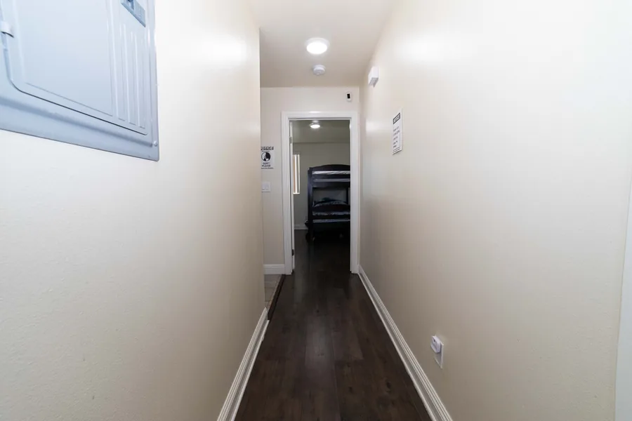 Hallway with wood look flooring leading to the shared bedrooms at the West 42nd Street house