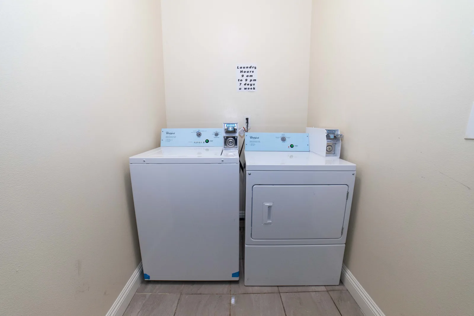 Laundry room at the West 42nd Street house with a washer a dryer and the posted laundry hours above them