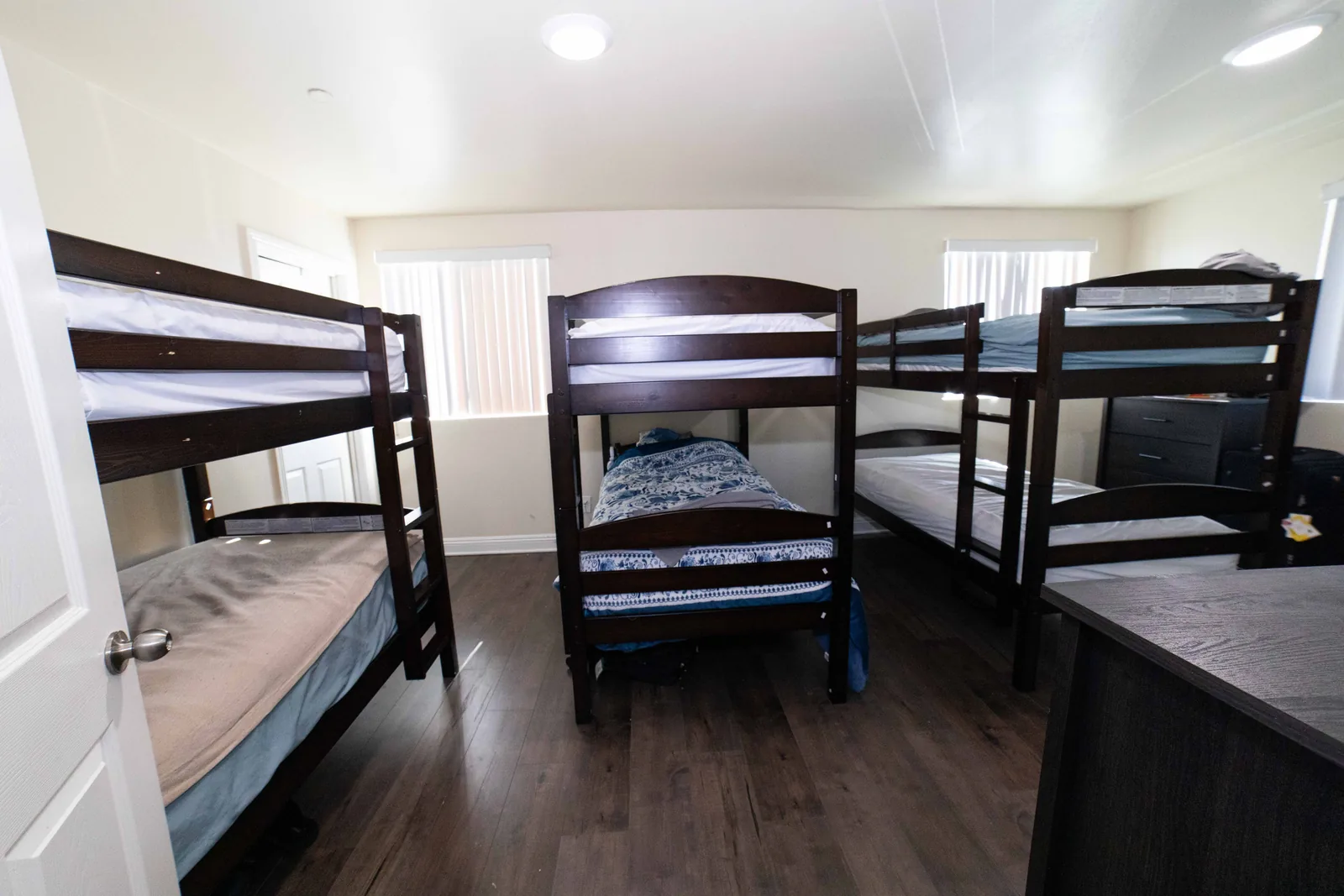 Wide view of a shared bedroom at the West 42nd Street house with bunk beds and a single bed