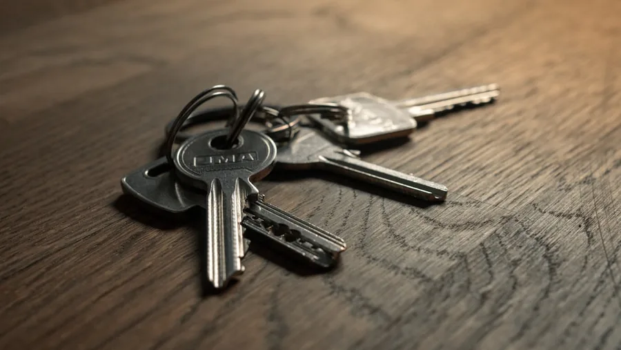 A set of house keys on a ring resting on a wooden table